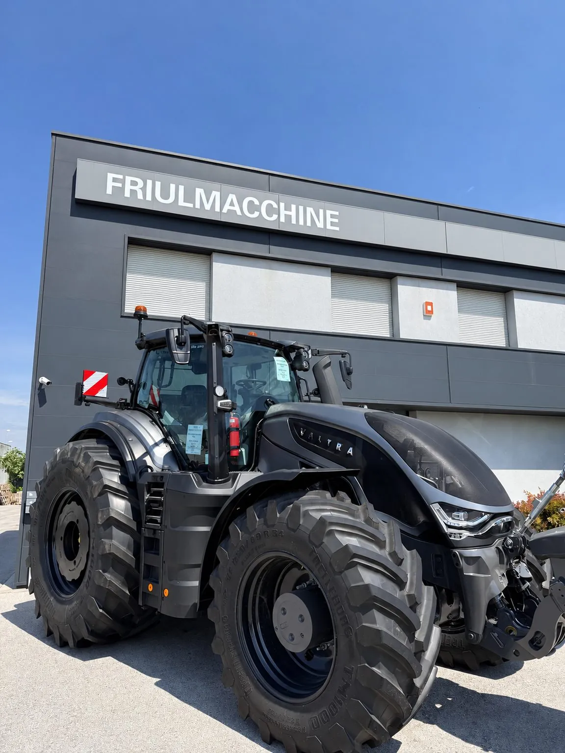 Trattore Valtra nero davanti alla sede Friulmacchine Srl